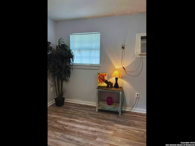 living area with wood-type flooring and a wall unit AC