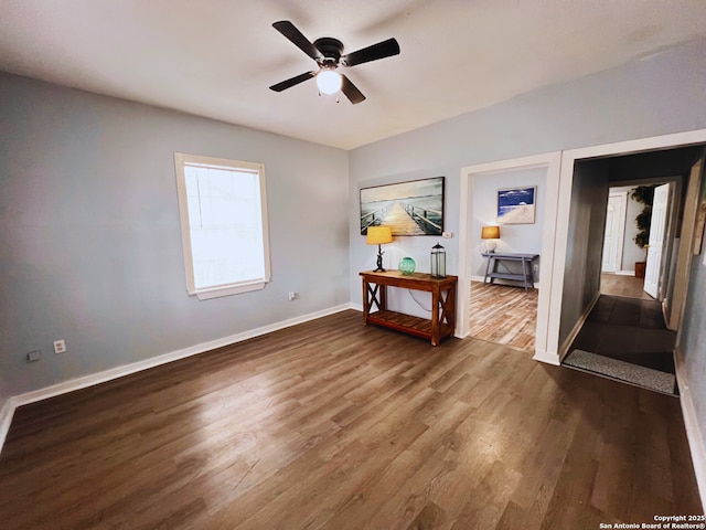 empty room with dark hardwood / wood-style floors and ceiling fan