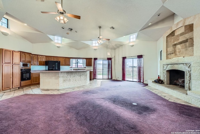 unfurnished living room featuring light carpet, high vaulted ceiling, a premium fireplace, and ceiling fan