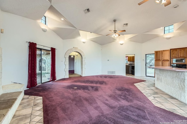 interior space featuring high vaulted ceiling, light colored carpet, and ceiling fan