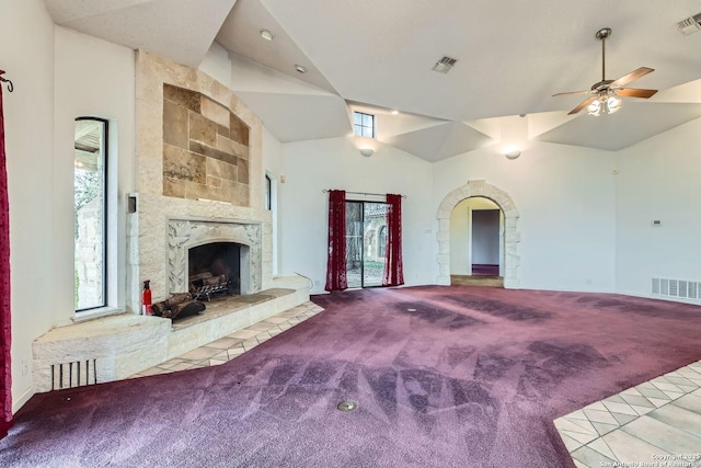 unfurnished living room featuring high vaulted ceiling, a tile fireplace, ceiling fan, and carpet flooring