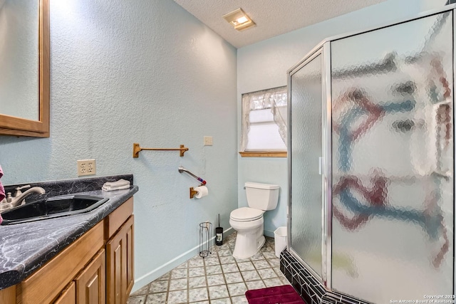 bathroom with vanity, a shower with door, toilet, and a textured ceiling