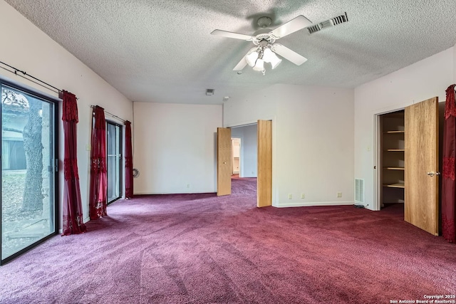 spare room featuring a textured ceiling, ceiling fan, and carpet flooring