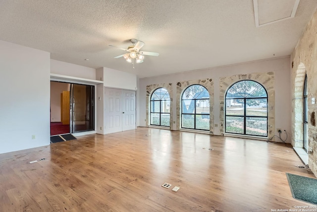 unfurnished room featuring ceiling fan, a textured ceiling, and light wood-type flooring