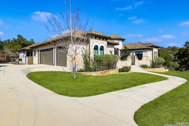 mediterranean / spanish-style home featuring a garage and a front yard