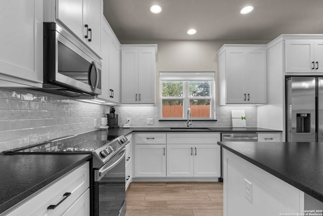 kitchen featuring tasteful backsplash, appliances with stainless steel finishes, sink, and white cabinets