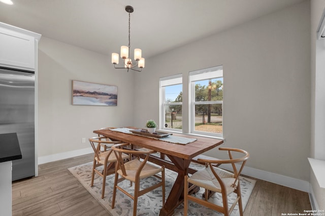 dining space with an inviting chandelier, light hardwood / wood-style floors, and breakfast area