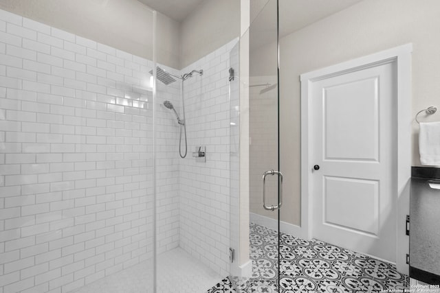 bathroom with an enclosed shower and tile patterned flooring