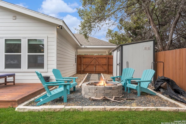 view of patio / terrace with a wooden deck, an outdoor fire pit, and a shed