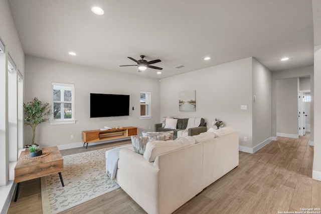 living room with ceiling fan and light hardwood / wood-style flooring