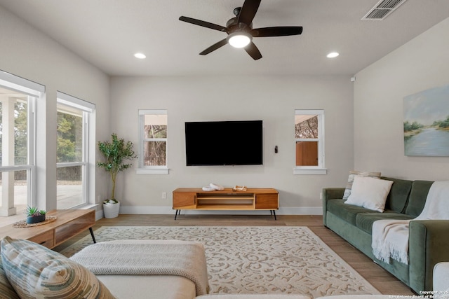 living room with wood-type flooring and ceiling fan