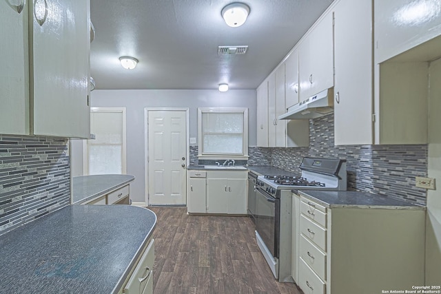 kitchen featuring white cabinetry, backsplash, dark hardwood / wood-style flooring, and gas range gas stove