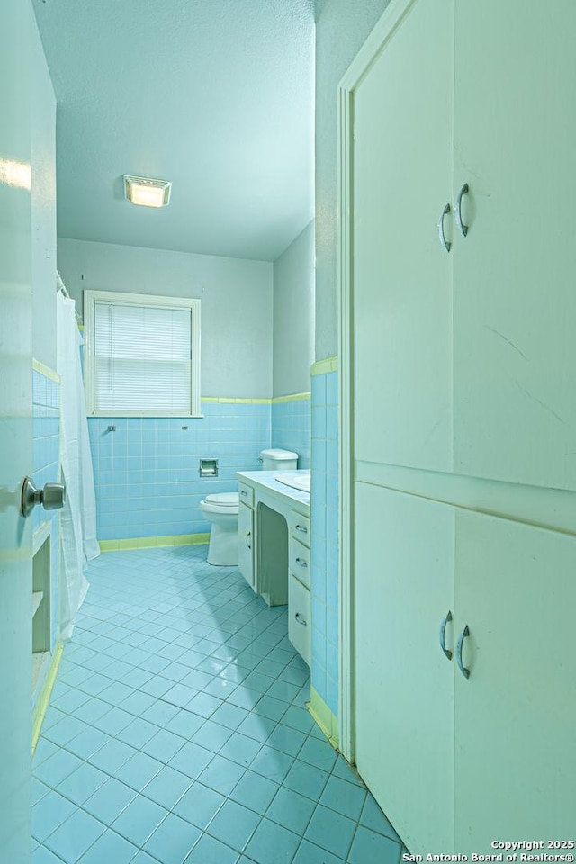 bathroom featuring tile walls, tile patterned flooring, vanity, toilet, and a shower with curtain