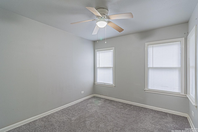 empty room featuring carpet, plenty of natural light, and ceiling fan