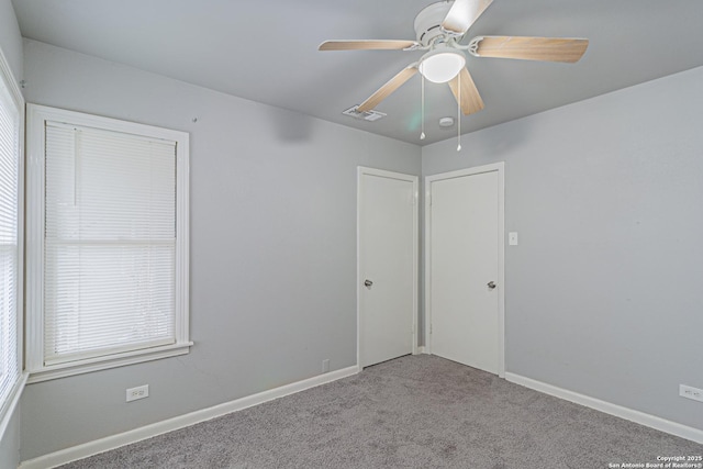 spare room featuring ceiling fan and light carpet