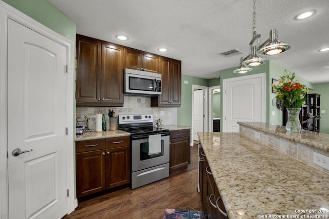 kitchen with dark brown cabinetry, tasteful backsplash, decorative light fixtures, appliances with stainless steel finishes, and dark hardwood / wood-style floors