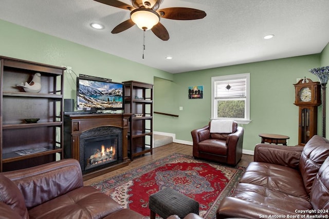 living room featuring ceiling fan and dark hardwood / wood-style flooring