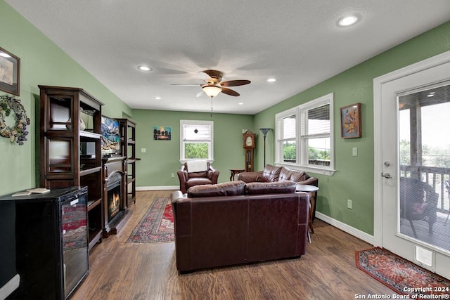 living room featuring dark wood-type flooring and ceiling fan