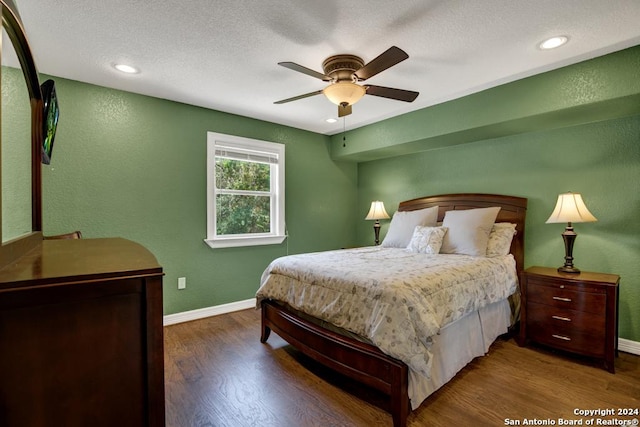 bedroom with a textured ceiling, dark hardwood / wood-style floors, and ceiling fan