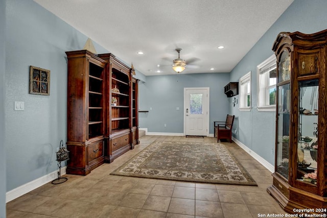 entrance foyer featuring ceiling fan, a textured ceiling, and light tile patterned floors