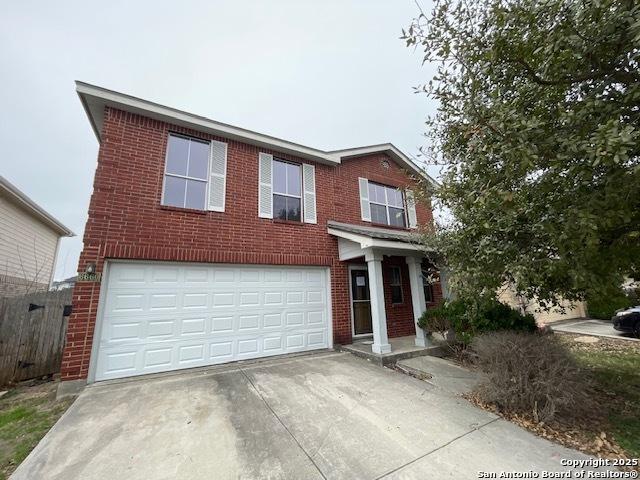 traditional home with concrete driveway, brick siding, and an attached garage