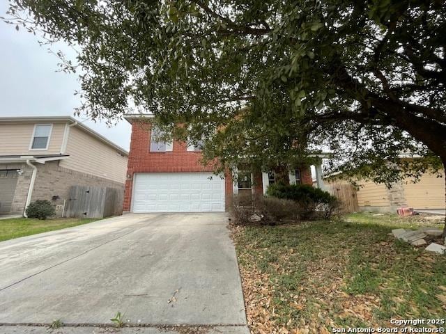 view of front of home with a garage, driveway, brick siding, and fence