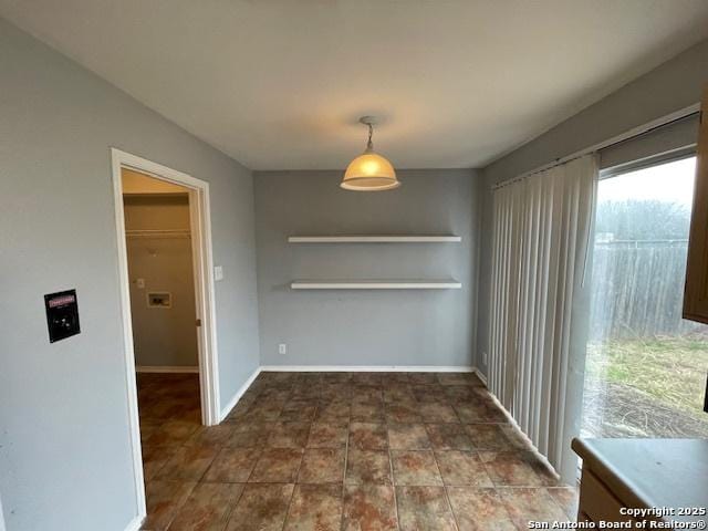 unfurnished dining area with baseboards