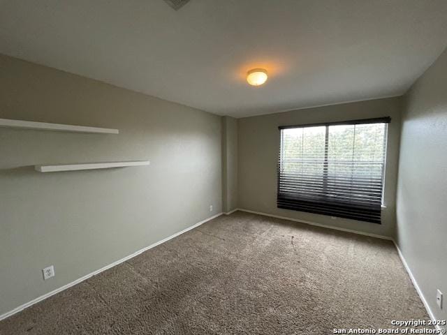 carpeted spare room with baseboards