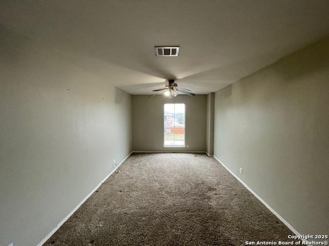 carpeted spare room with ceiling fan, visible vents, and baseboards