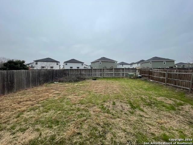 view of yard featuring a fenced backyard and a residential view