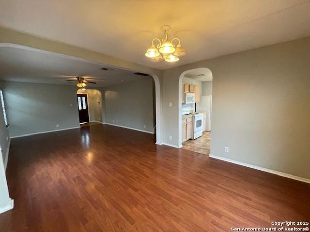 unfurnished room with baseboards, arched walkways, wood finished floors, and ceiling fan with notable chandelier