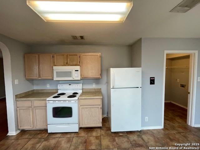 kitchen featuring arched walkways, light countertops, visible vents, light brown cabinets, and white appliances