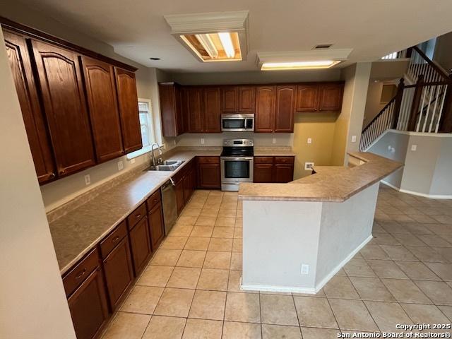 kitchen featuring appliances with stainless steel finishes, sink, and light tile patterned floors