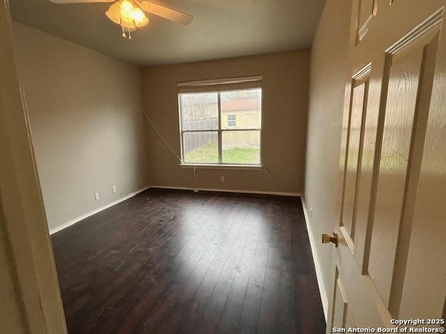 spare room with ceiling fan and dark hardwood / wood-style flooring