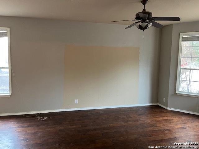 spare room with ceiling fan and dark hardwood / wood-style flooring