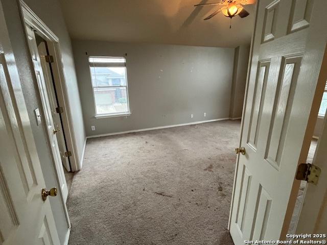 interior space with light colored carpet and ceiling fan