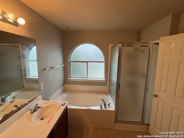 bathroom featuring independent shower and bath and vanity