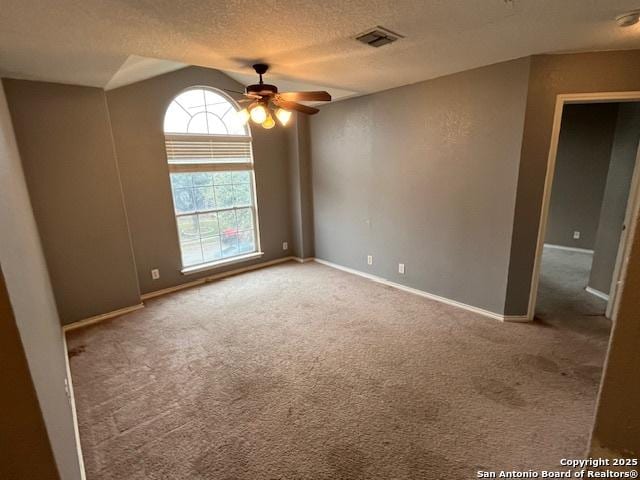 carpeted spare room with ceiling fan and a textured ceiling