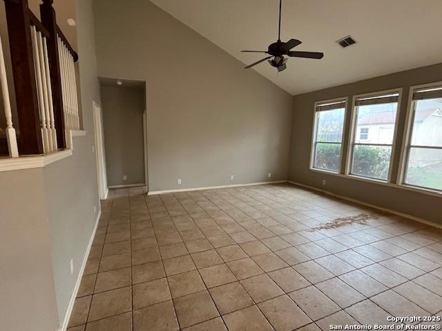 spare room with high vaulted ceiling, light tile patterned floors, and ceiling fan