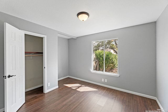 unfurnished bedroom featuring dark wood-type flooring and a closet