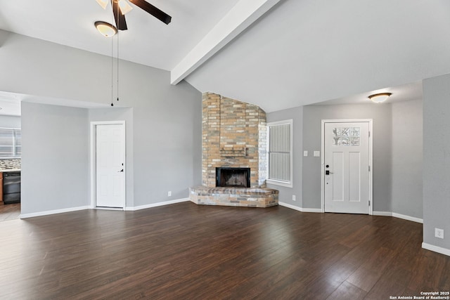 unfurnished living room featuring dark wood-type flooring, ceiling fan, a brick fireplace, and vaulted ceiling with beams