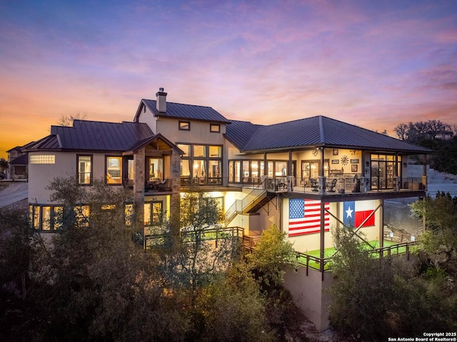 back house at dusk with a balcony