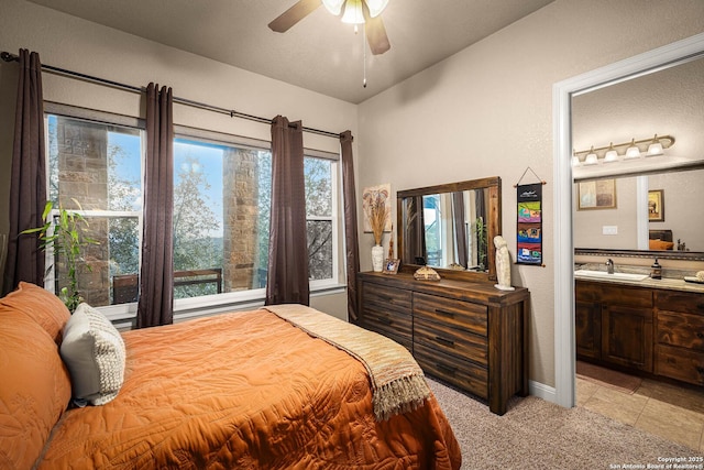 carpeted bedroom featuring sink, ceiling fan, and ensuite bathroom