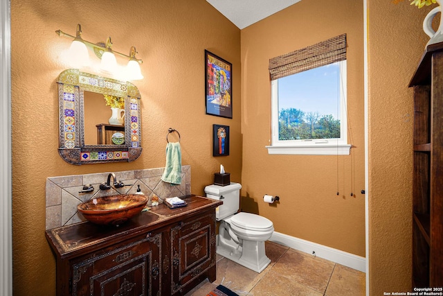 bathroom with tile patterned flooring, vanity, tasteful backsplash, and toilet