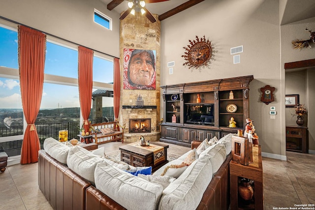 tiled living room featuring a stone fireplace, a towering ceiling, and ceiling fan