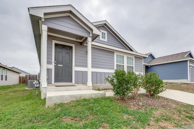 view of front of property with central AC and a front lawn