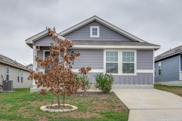 bungalow-style home featuring central AC unit and a front lawn