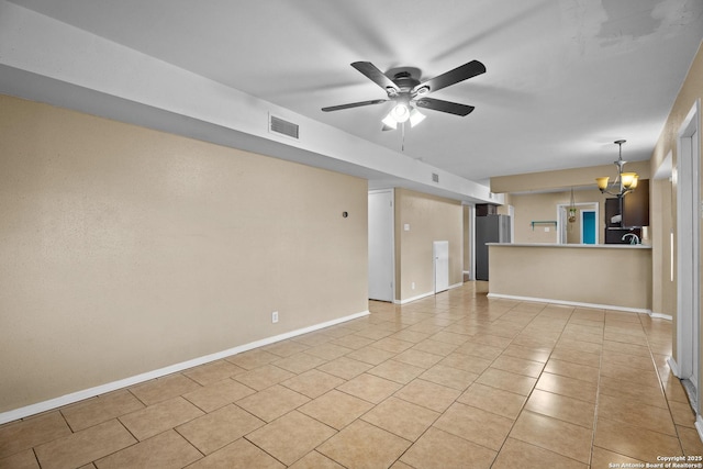 unfurnished living room with ceiling fan with notable chandelier and light tile patterned flooring