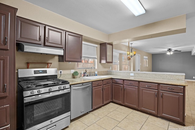 kitchen with stainless steel appliances, light tile patterned flooring, sink, and kitchen peninsula