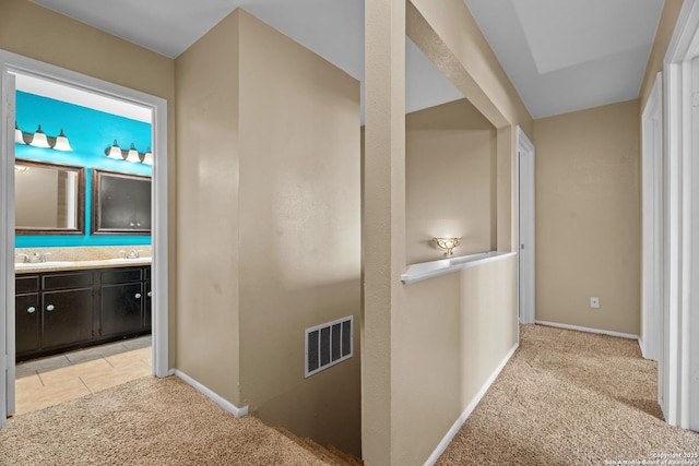 corridor with light colored carpet and sink